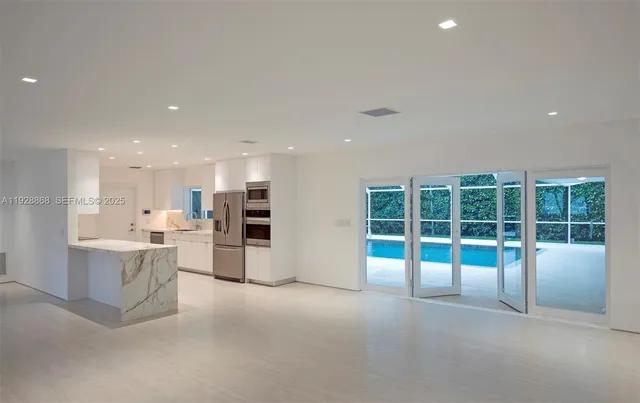 a kitchen with stainless steel appliances kitchen island granite countertop a refrigerator and a sink