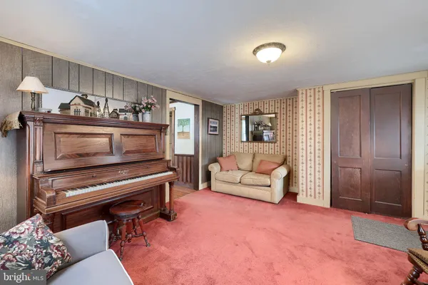a living room with furniture and a piano