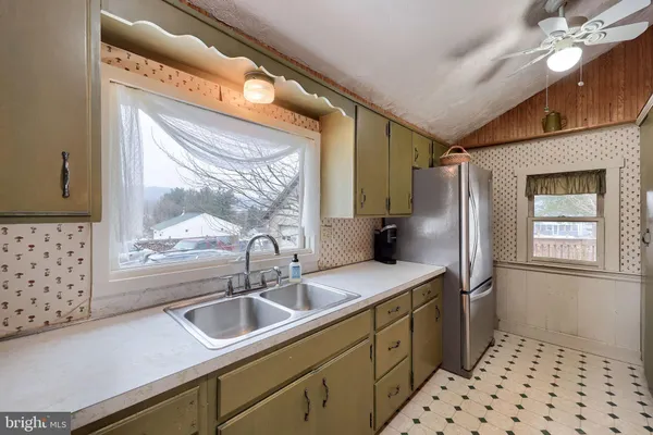 a kitchen with stainless steel appliances a sink window and cabinets