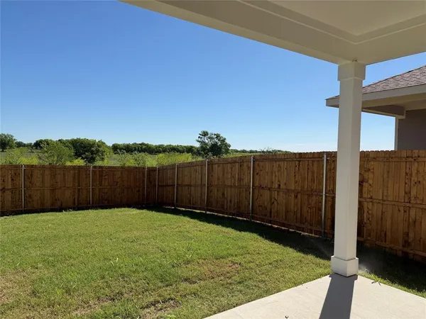 a view of a backyard with wooden fence