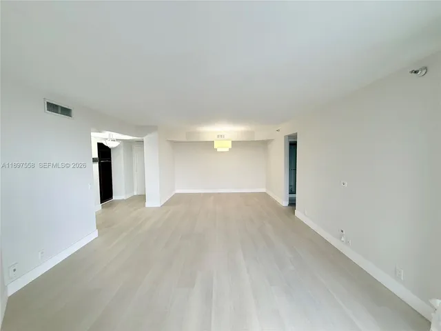 a view of living room with stainless steel appliances cabinets and a flat screen tv
