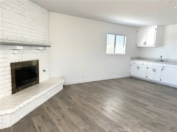 a kitchen with granite countertop a stove fireplace and a wooden floor