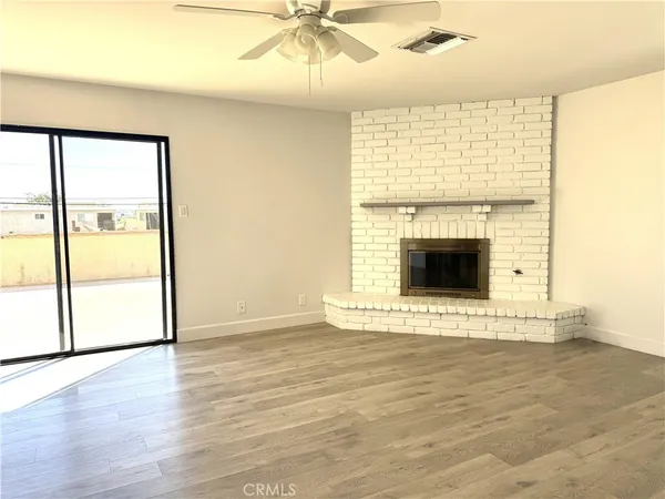 a view of an empty room with a fireplace and a window