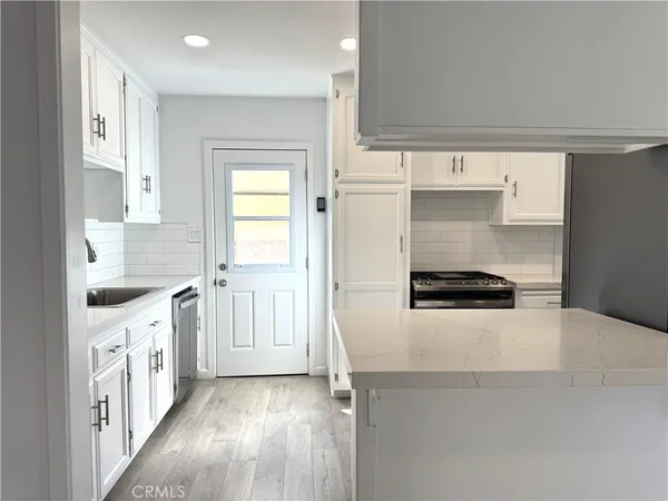 a kitchen with granite countertop a sink and a stove top oven
