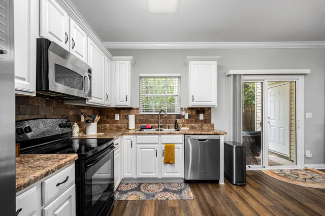 a kitchen with stainless steel appliances granite countertop a stove a sink and a microwave