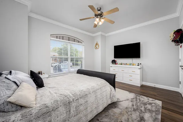 a bedroom with a bed tv and a window