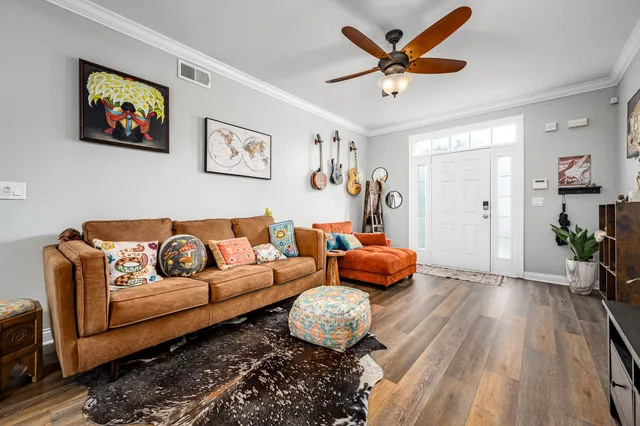 a living room with furniture and a wooden floor