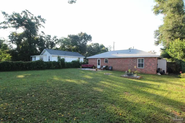 a view of a yard in front of a house with large trees