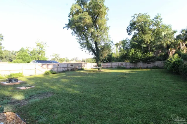 a view of yard with swimming pool and green space