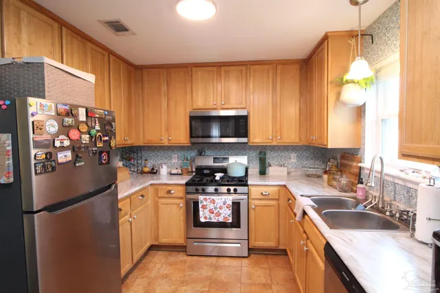 a kitchen with stainless steel appliances granite countertop a refrigerator stove and sink