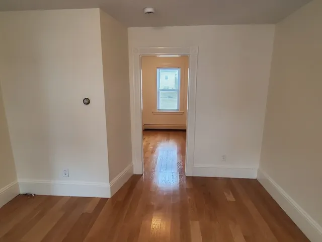 an empty room with wooden floor and a window