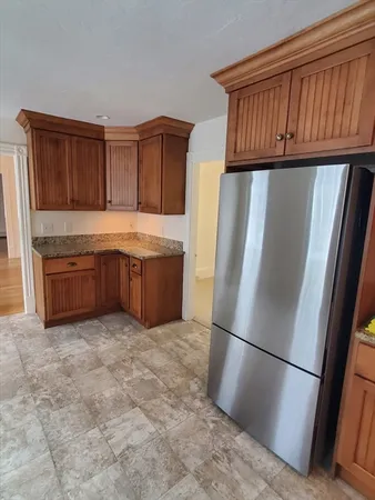 a view of kitchen with stainless steel appliances granite countertop a refrigerator and a sink