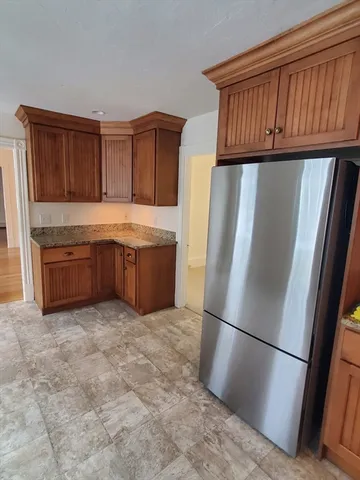 a view of kitchen with stainless steel appliances granite countertop a refrigerator and a sink