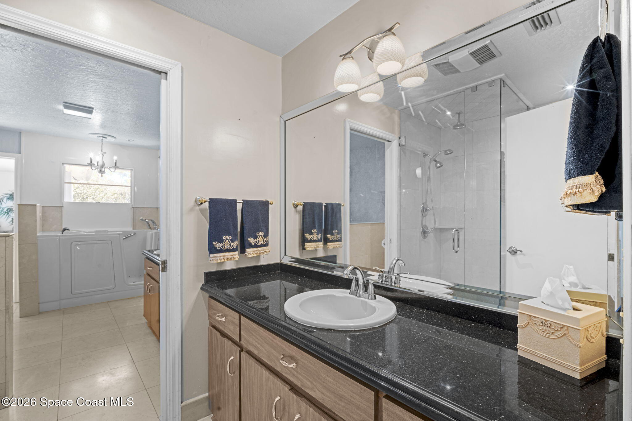 620 West Pine Road Melbourne, FL 32904 - Photo 16 of 32 a en suite bathroom with a double vanity sink mirror and shower
