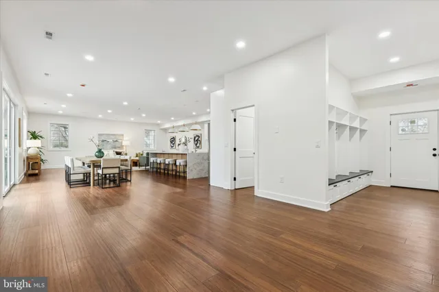 an empty room with wooden floor ceiling fan and windows