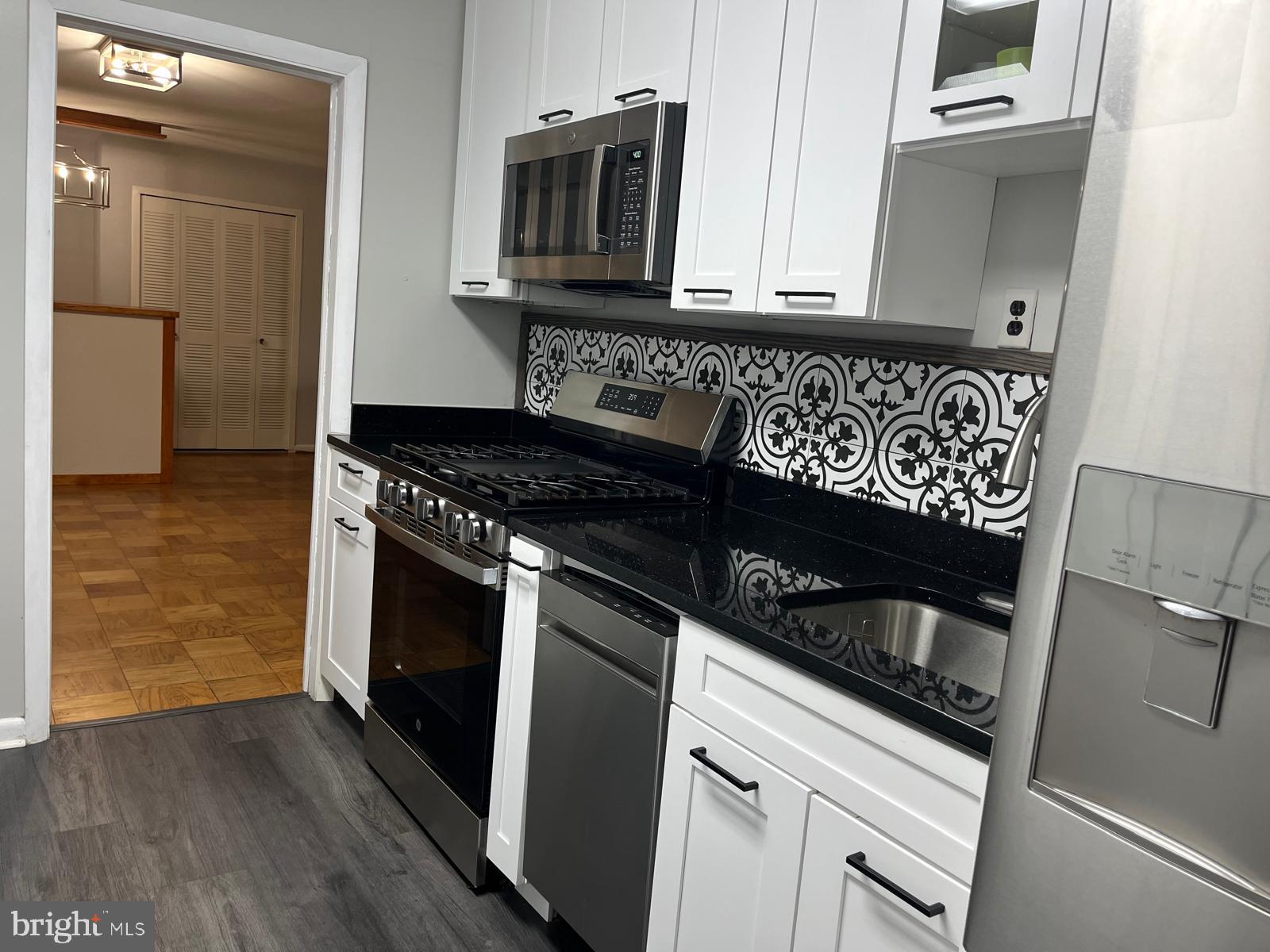 5101 River Road, Unit 405 Bethesda, MD 20816 - Photo 11 of 20 a kitchen with granite countertop a stove and a microwave