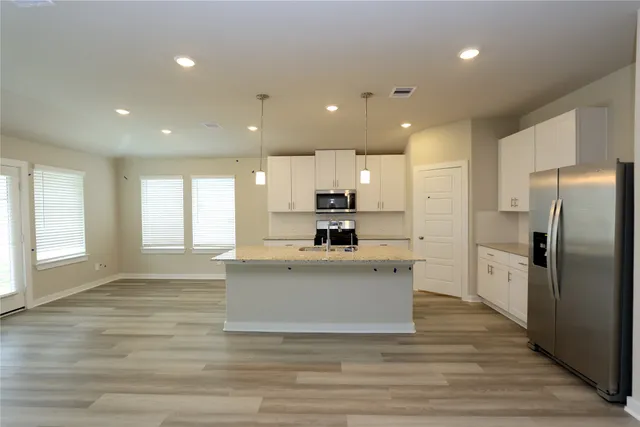 a large kitchen with kitchen island a sink stainless steel appliances and cabinets