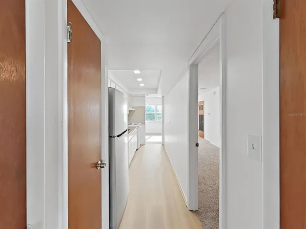 a view of a hallway with wooden shelves