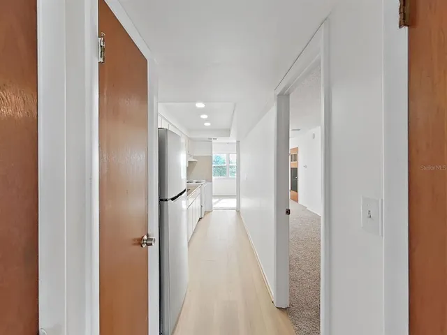 a view of a hallway with wooden shelves