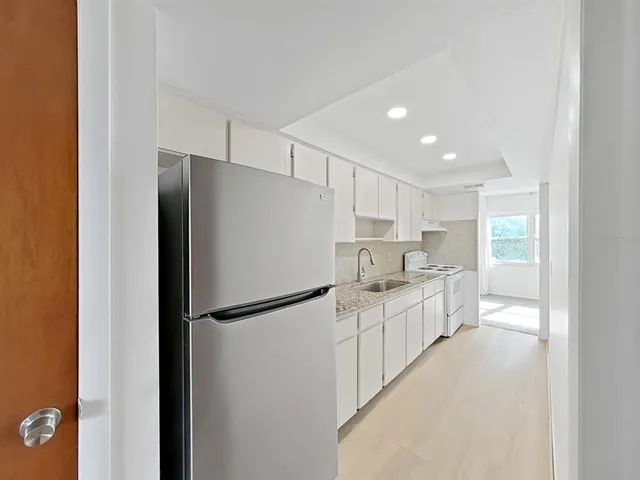 a kitchen with white cabinets and white appliances