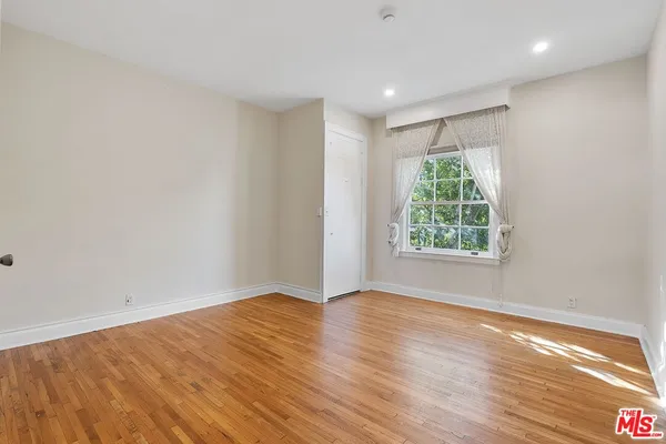 a view of empty room with wooden floor