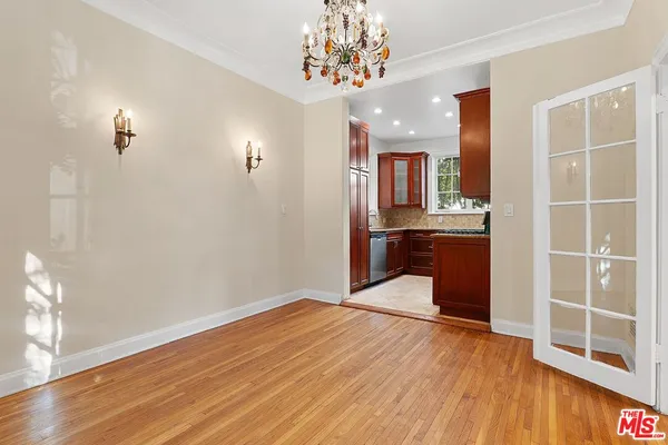 a view of a room with wooden floor and a ceiling fan