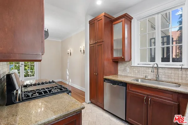 a kitchen with stainless steel appliances granite countertop a sink stove and cabinets