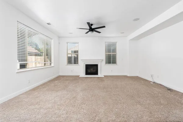 a view of empty room with fireplace and windows