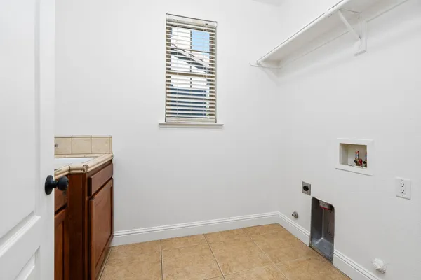 an empty room with a chandelier fan and windows