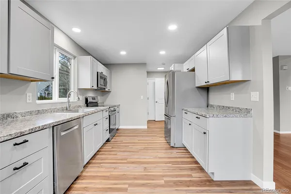 a large kitchen with stainless steel appliances granite countertop a stove and a sink