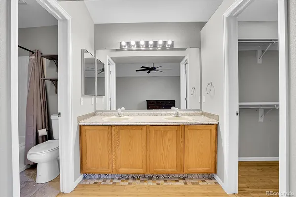 a bathroom with a granite countertop sink mirror vanity and toilet