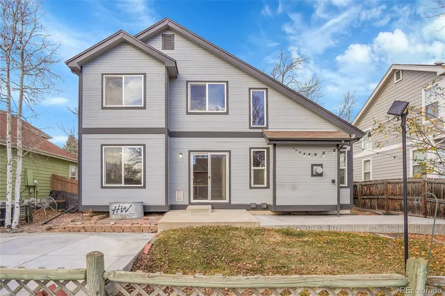 a view of a white house with large windows next to a road