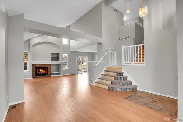 a view of a livingroom with wooden floor and a fireplace