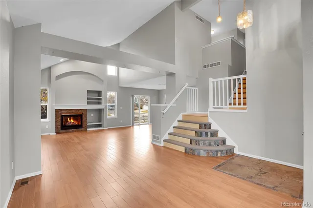 a view of a livingroom with wooden floor and a fireplace