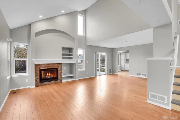 a view of an empty room with a fireplace and a window