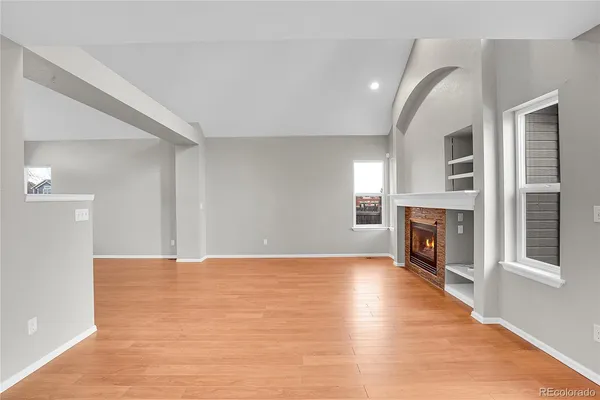 a view of an empty room with a fireplace and a window