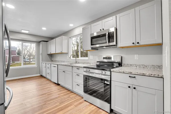 a kitchen with stainless steel appliances granite countertop a stove sink and cabinets