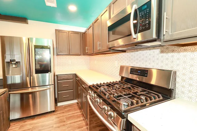 a kitchen with wooden cabinets and stainless steel appliances
