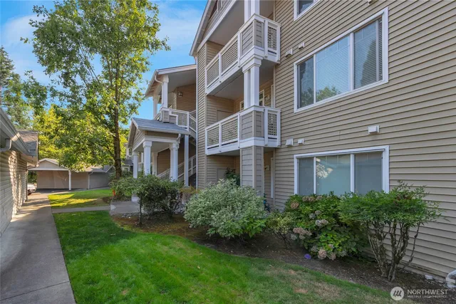 a front view of a house with garden and trees