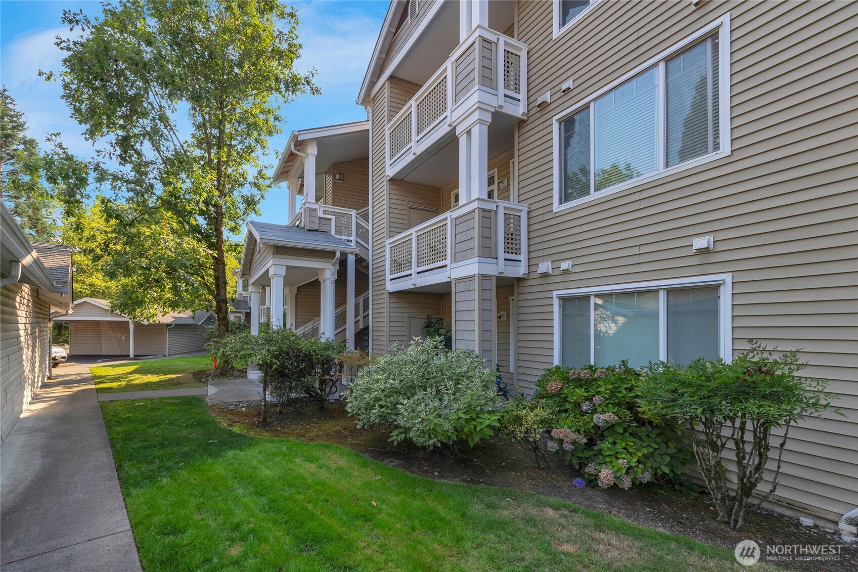 a front view of a house with garden and trees