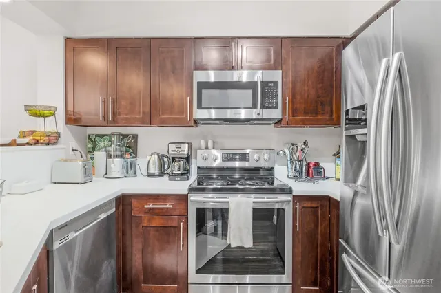a kitchen with stainless steel appliances granite countertop a refrigerator stove and sink