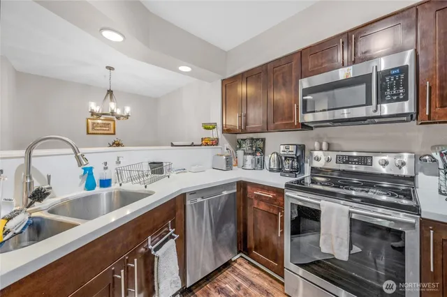 a kitchen with stainless steel appliances granite countertop a sink stove and microwave