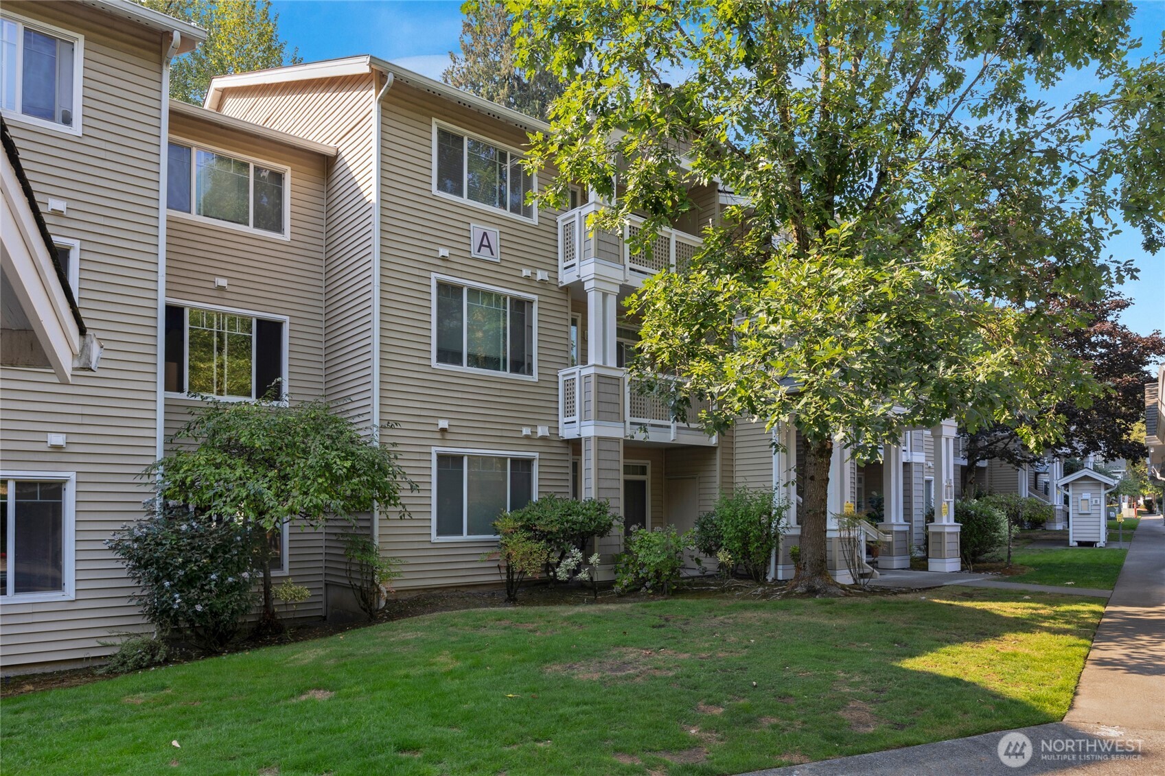 15300 112th Avenue Northeast, Unit A304 Bothell, WA 98011 - Photo 27 of 28 a front view of a house with a yard and trees
