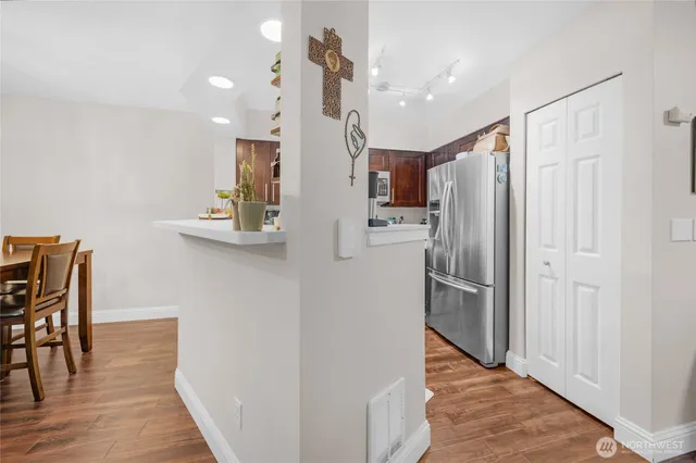 a kitchen with stainless steel appliances a refrigerator and wooden floor
