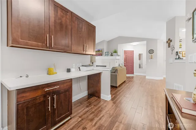 a kitchen with a sink a stove cabinets and wooden floor