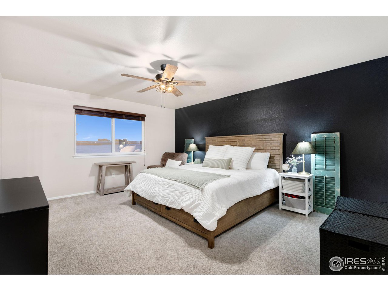 7334 23rd St Road Greeley, CO 80634 - Photo 16 of 31 a spacious bedroom with a bed and a chandelier