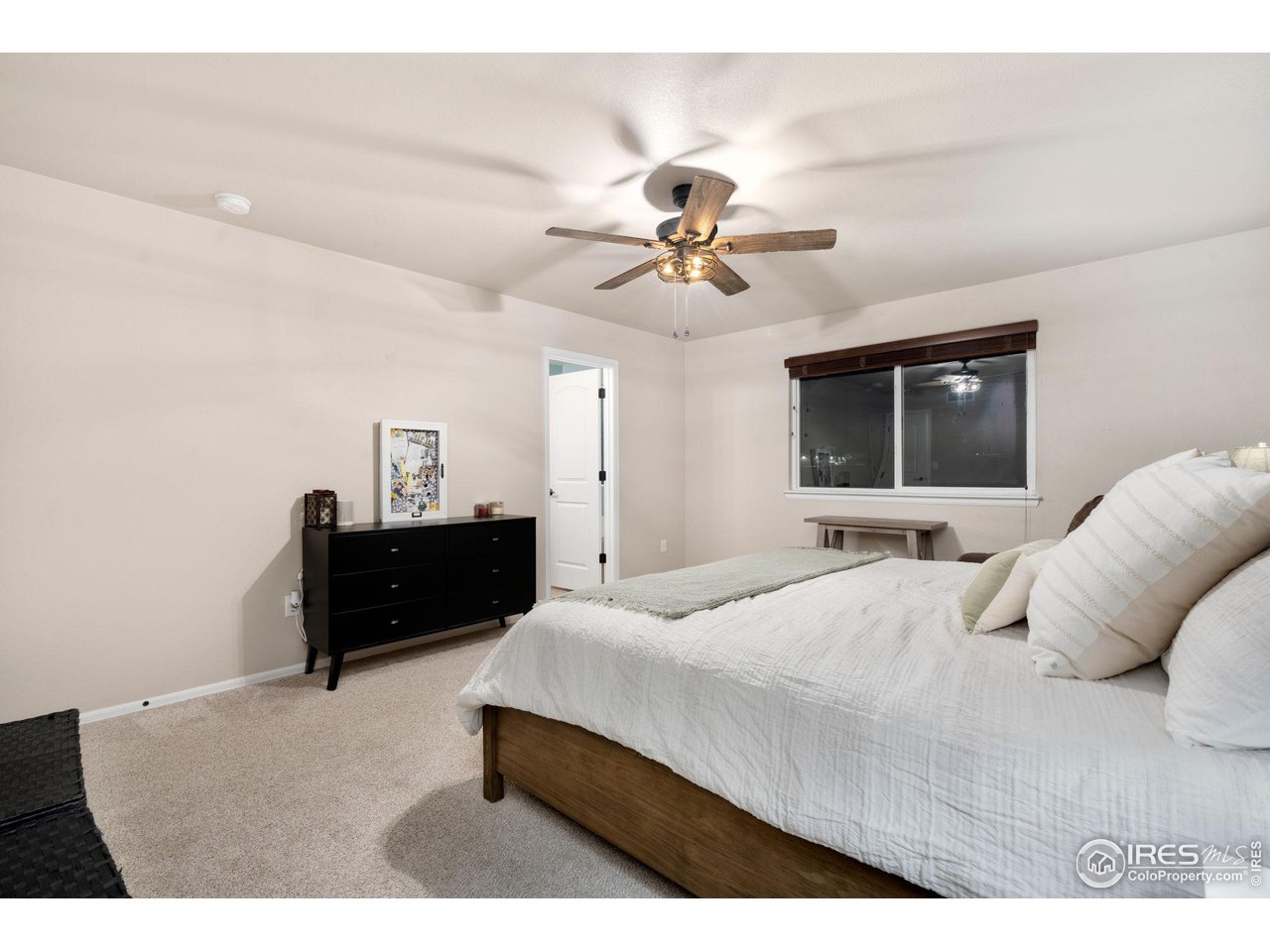 7334 23rd St Road Greeley, CO 80634 - Photo 26 of 31 a bedroom with a bed and a chandelier
