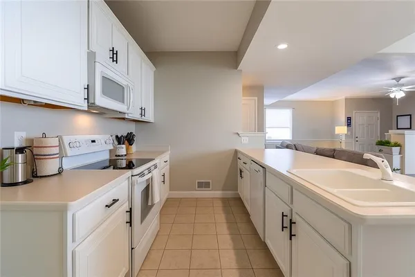 a kitchen with white cabinets and white appliances
