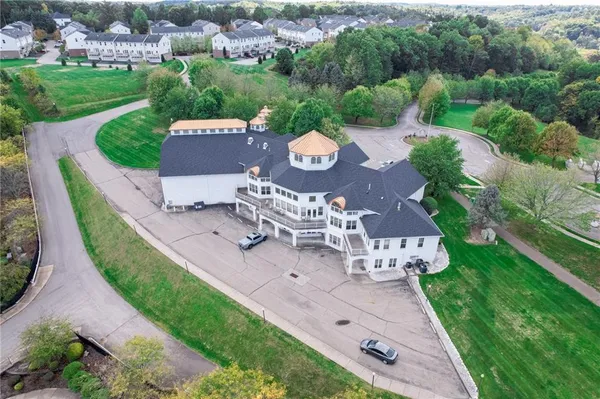 an aerial view of a house with a garden and lake view