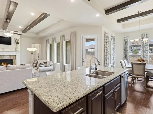 a kitchen with granite countertop a sink counter top space and living room view